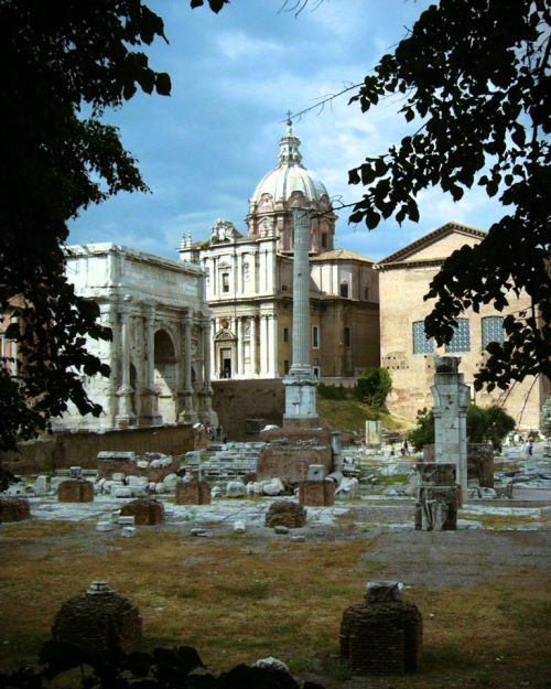 An image showcasing historic Roman ruins with classical architecture, columns, and ancient structures in a scenic outdoor setting, highlighting Italy’s rich archaeological heritage.
