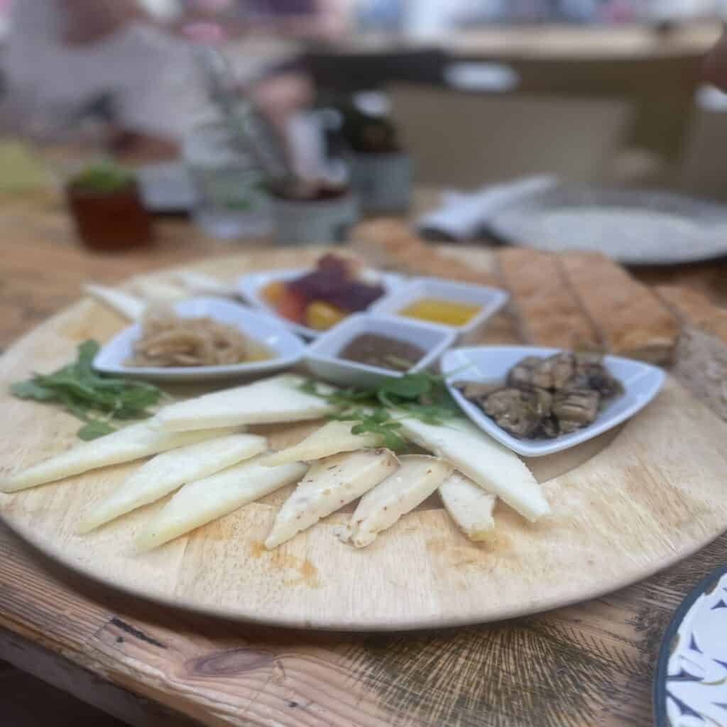Authentic Italian cheese and seafood tasting plate featuring fresh cheeses, marinated seafood, and flavorful dipping sauces.